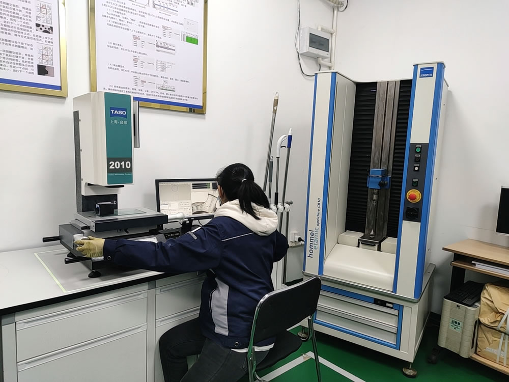 A woman is operating an automatic glue spraying machine