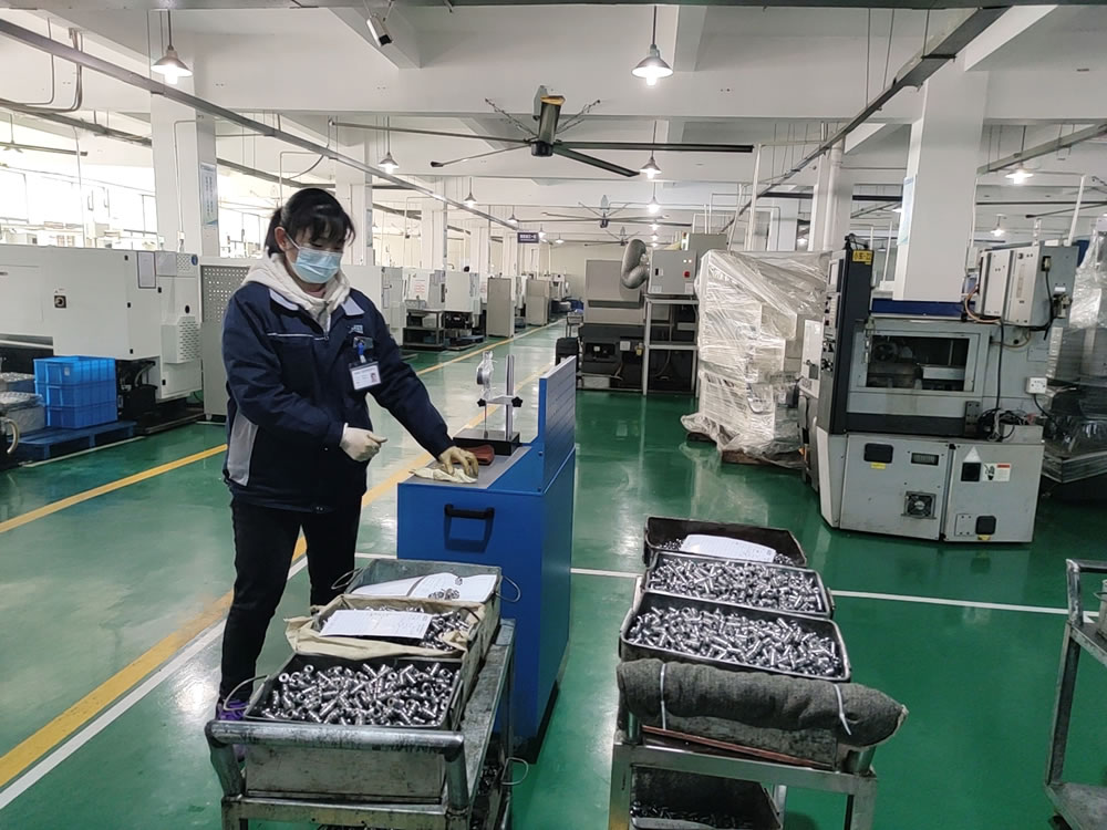 a woman wearing gloves is checking a heated nozzle for a 3d printer