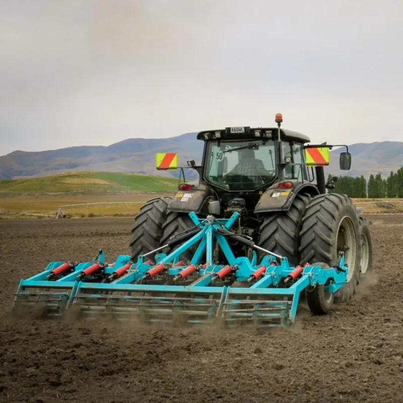 A tractor is dragging a plow to cultivate in the field